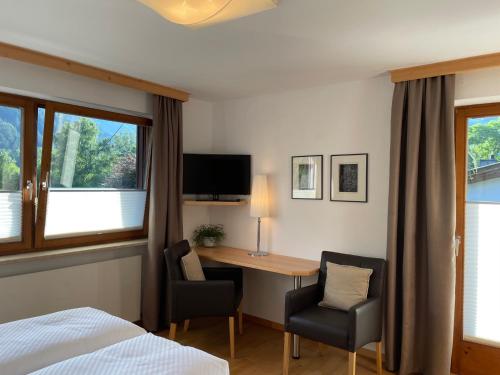 a bedroom with a desk and a bed and a desk and chairs at Appartements Falkner Dorli in Oetz