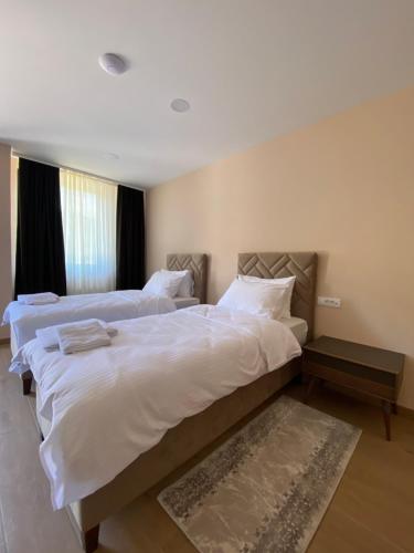 福查的住宿－Apartmani Nešković Foča，配有白色床单的酒店客房内的两张床