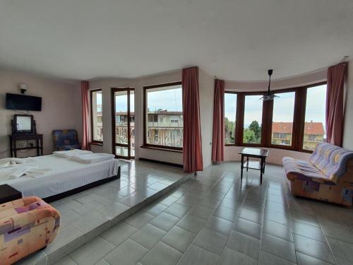 1 dormitorio con 1 cama, sillas y ventanas en Lazur Hotel, en Ravda
