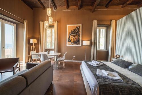 a bedroom with two beds and a couch and a table at Residenza Nausicaa - 50 meters from the beach in Pizzo