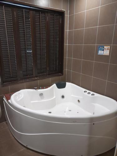 Una bañera blanca en un baño con ventana. en 5pax Gold Coast Morib Resort - Banting Sepang KLIA Tanjung Sepat, en Banting