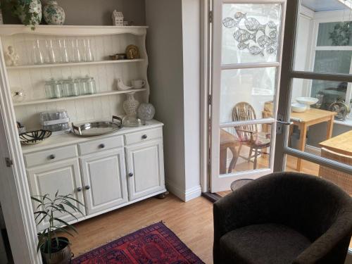uma cozinha com um lavatório e uma cadeira num quarto em Parsnips House BnB Glastonbury em Glastonbury