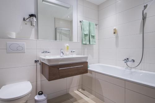 een badkamer met een wastafel, een bad en een toilet bij Ferienhaus Casa Luna in Zermatt