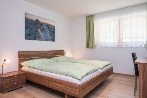 1 dormitorio con cama, escritorio y ventana en Ferienhaus Casa Luna, en Zermatt