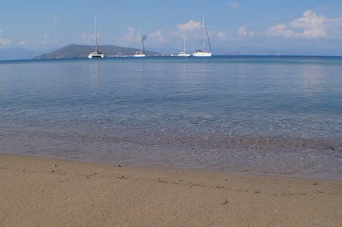 a sandy beach with boats in the water at Anatoli Hotel in Agia Marina Aegina