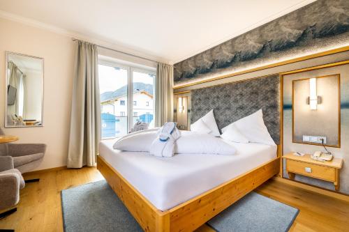 a bedroom with a large bed and a window at Schlosshotel Lacknerhof in Flachau
