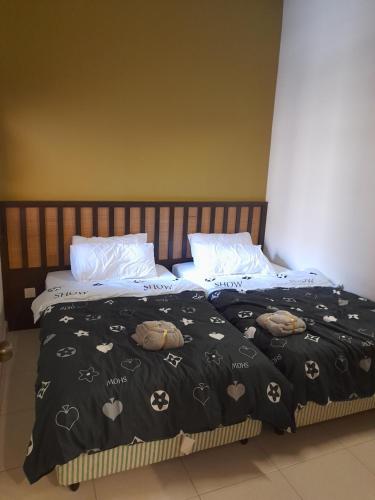a bed with a black blanket with hearts on it at 8pax Gold Coast Morib Resort - Banting Sepang KLIA Tanjung Sepat ebaa in Banting
