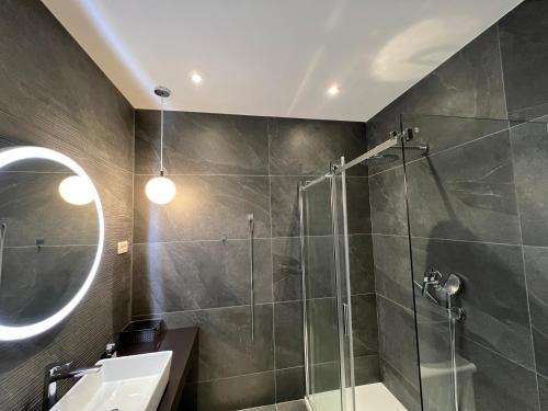 W łazience znajduje się prysznic, umywalka i lustro. w obiekcie Apartments Adriatic Blue w Dubrowniku
