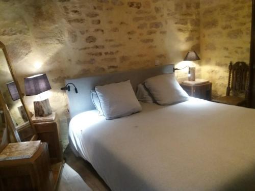a bedroom with a large white bed with two pillows at LE LOFT DE LA SALAMANDRE SARLAT in Sarlat-la-Canéda