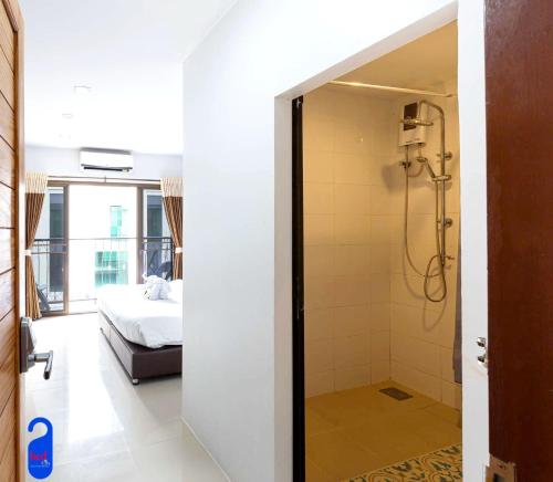 a bathroom with a shower and a bedroom at Bed By City Hotel in Bangkok