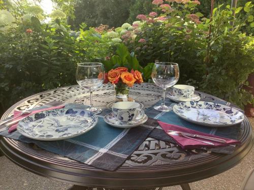 a table with plates and wine glasses on it at Toute Une Histoire près de Fontainebleau in Veneux-les-Sablons