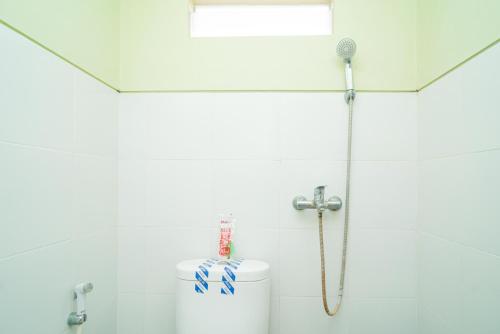 a shower in a bathroom with a blow dryer at RedDoorz Syariah near Suncity Mall Sidoarjo in Sidoarjo