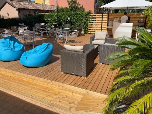 a patio with blue chairs and tables and chairs at Hotel Apogeo - Breakfast Experience in Rimini