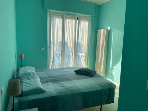 a blue bedroom with a bed and a window at Ocean View Villa with Fast WI-FI and Elevator to Town in Levanto