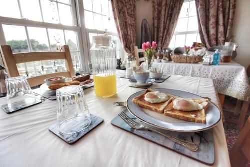 einen Tisch mit zwei Teilen Toast mit Hühnchen drauf. in der Unterkunft Melorne Farm Guest House in Camelford