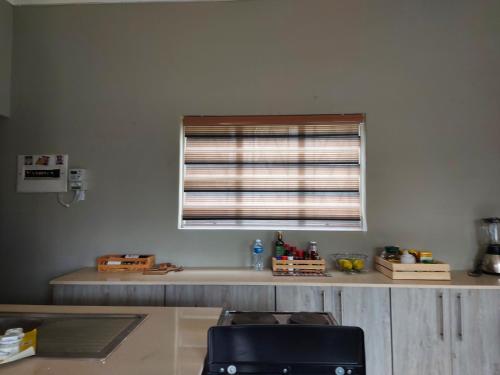 a kitchen with a counter with a window and a sink at Recoupe in East London