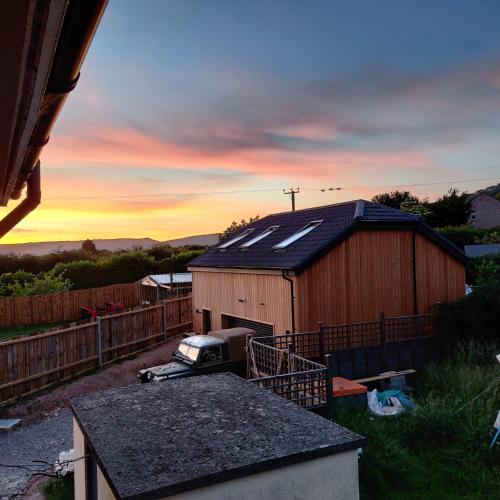 a barn with a truck parked in front of it at The Studio Cheddar - With Wood Fired Hot Tub, Near Cheddar Gorge in Draycott