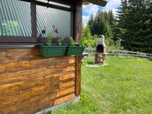 a fence with potted plants on the side of a house at Bungalows Krstajić in Žabljak