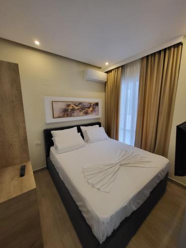 a bedroom with a large white bed in front of a window at HotelApart - DelMar in Durrës