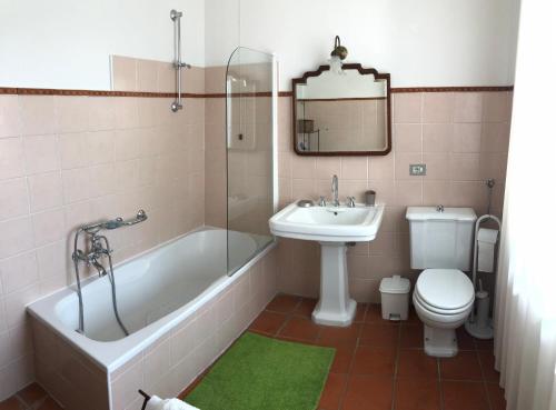 a bathroom with a tub and a sink and a toilet at Agriturismo La Casa in Collina in Canelli