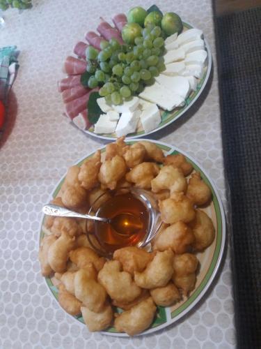 two plates of food on a table with grapes at Auto camp Radoman in Virpazar