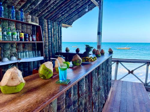 Equalia boutique hotel في جامبياني: يوجد بار به مشروب وطعام على الشاطئ