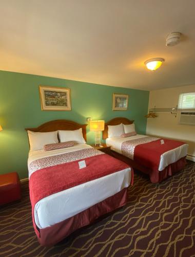 two beds in a hotel room with green walls at Cozy Corner Motel in Williamstown