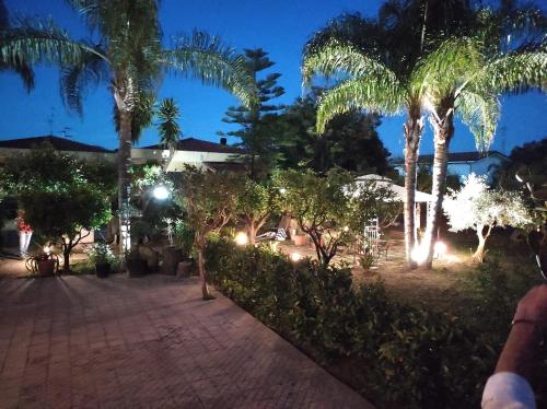 a resort at night with palm trees and lights at La Casetta B&B in Milazzo