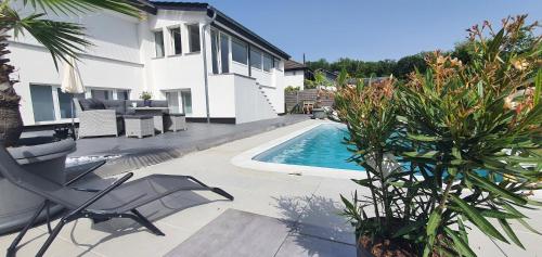 un patio trasero con piscina y una casa en Unsere Unterkünfte Ferienwohnung Superior für 1-4 Personen und Cozy Apartment für 1-2 Personen, en Goslar