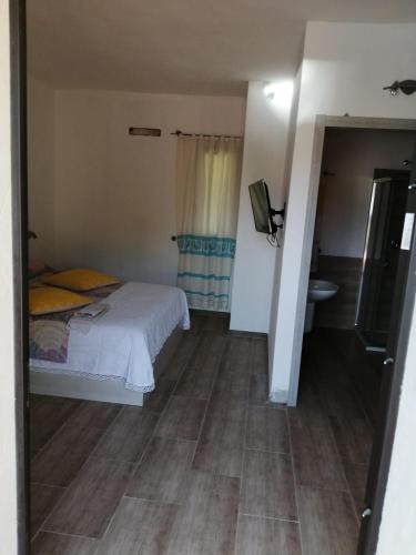 a small bedroom with a bed and a bathroom at Elia's House in Padru