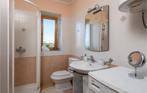 ein Badezimmer mit einem WC, einem Waschbecken und einem Spiegel in der Unterkunft 2 Bedroom Cozy Home In Krnica in Krnica