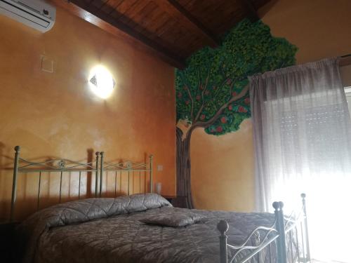 a bedroom with a tree painted on the wall at La Casetta B&B in Milazzo