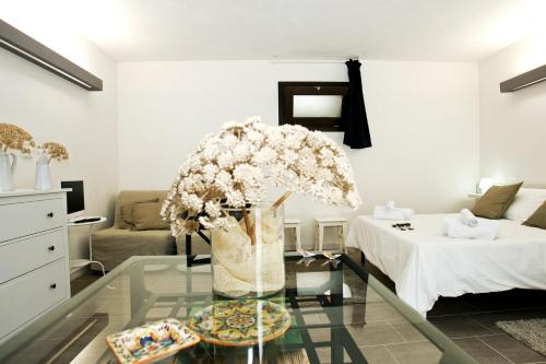 a living room with a vase of flowers on a glass table at Residence San Martino in Erice