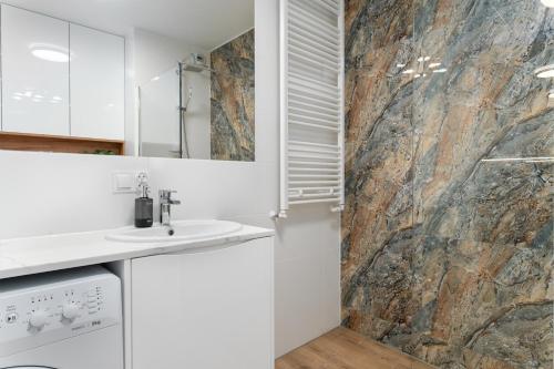 a bathroom with a sink and a stone wall at Star4You II Apartments in Wrocław