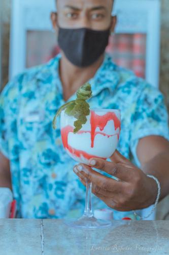 a man wearing a face mask holding a wine glass at Paradiso Peró Praia Hotel in Cabo Frio