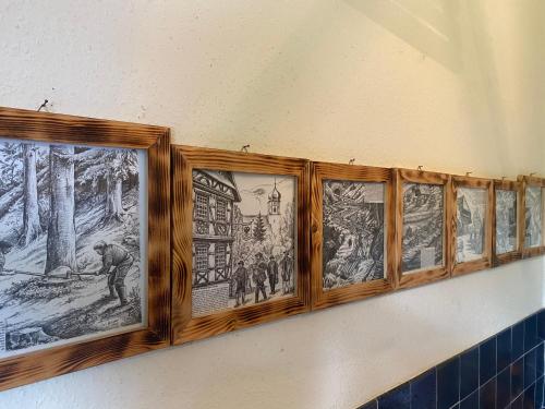 a row of drawings on a wall in a bathroom at S-VILLA Apartments im Schwarzwald in Schiltach