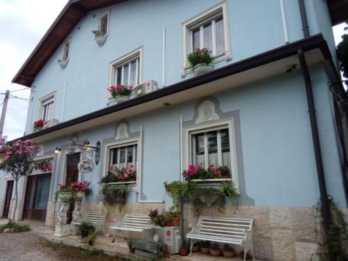 a white building with benches in front of it at Villa Fiorita in Monfalcone