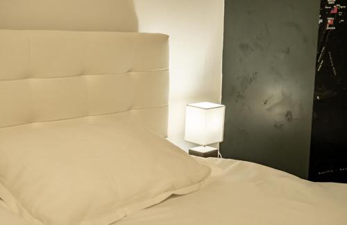a bedroom with a white bed and a lamp at Studio Six Continents in Petroşani