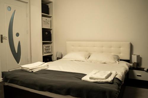 a bedroom with a bed with two towels on it at Studio Six Continents in Petroşani