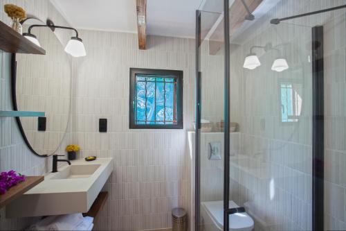 a white bathroom with a sink and a shower at Villa bodri, maison en pierre avec vue mer et piscine chauffée in LʼÎle-Rousse