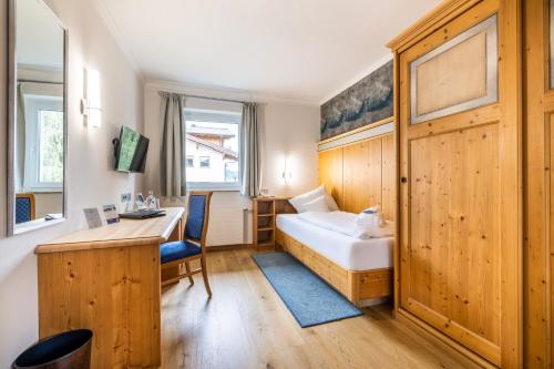 a hotel room with a bed and a desk at Schlosshotel Lacknerhof in Flachau