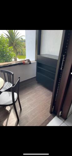 a balcony with a chair and a table and a window at Bahia Smir in Restinga Smir