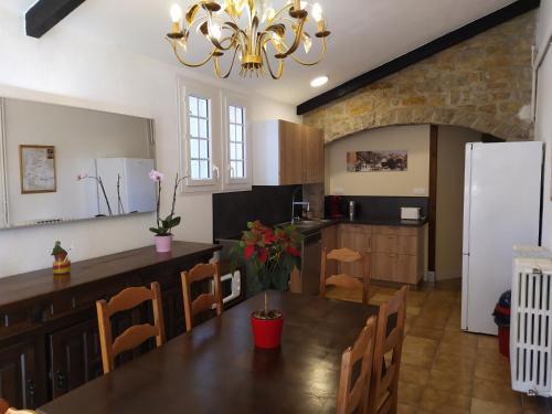 Il comprend une cuisine et une salle à manger avec une table et un réfrigérateur. dans l'établissement Gîtes "La Sérénité Marivaloise", à Lacapelle-Marival