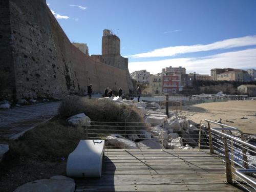 a wooden walkway next to a wall with a building at Azzurro come il Mare in Termoli