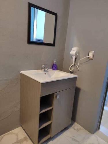 a bathroom with a sink and a mirror at Apartamento 2 recamaras en el corazón de Cozumel in Cozumel