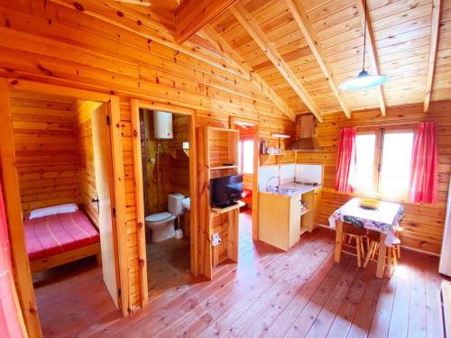 Cabaña de madera con dormitorio y baño en Bungalows Camping Ferrer, en Peñíscola