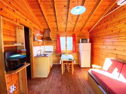 a cabin with a kitchen and a table in it at Bungalows Camping Ferrer in Peñíscola