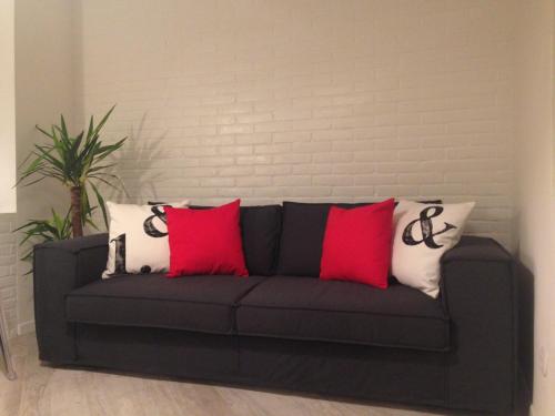 a black couch with red and white pillows on it at Les Suites di Parma in Parma