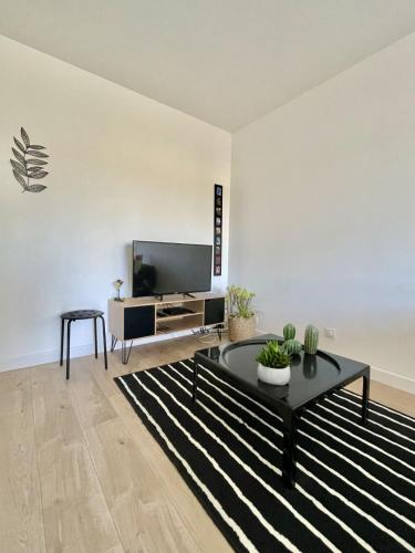 un salon avec une télévision et une table basse dans l'établissement LUMINEUX 35 m pour 2 - Centre-ville, à Cagnes-sur-Mer