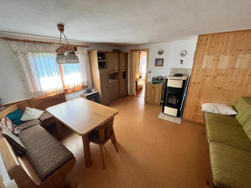 uma sala de estar com uma mesa e uma cozinha em Trentino Val Rendena casa con vista 3 camere doppie e 2 bagni em Groppe de Fora